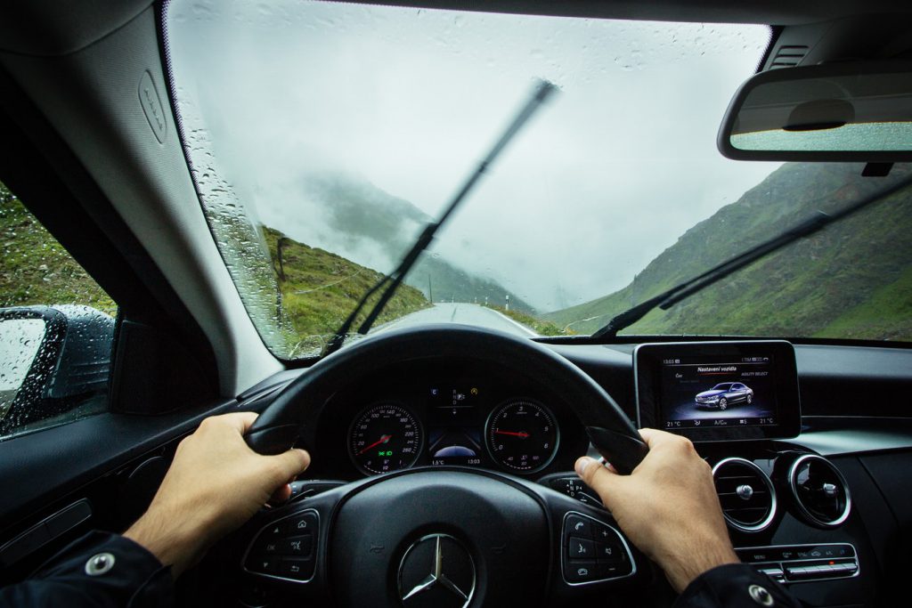 Conducteur au volant de sa voiture sous la pluie